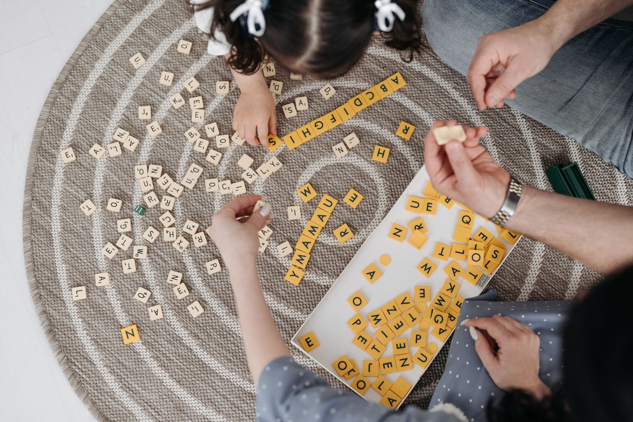 High angle shot of a family playing a word game together indoors, enjoying quality bonding time.